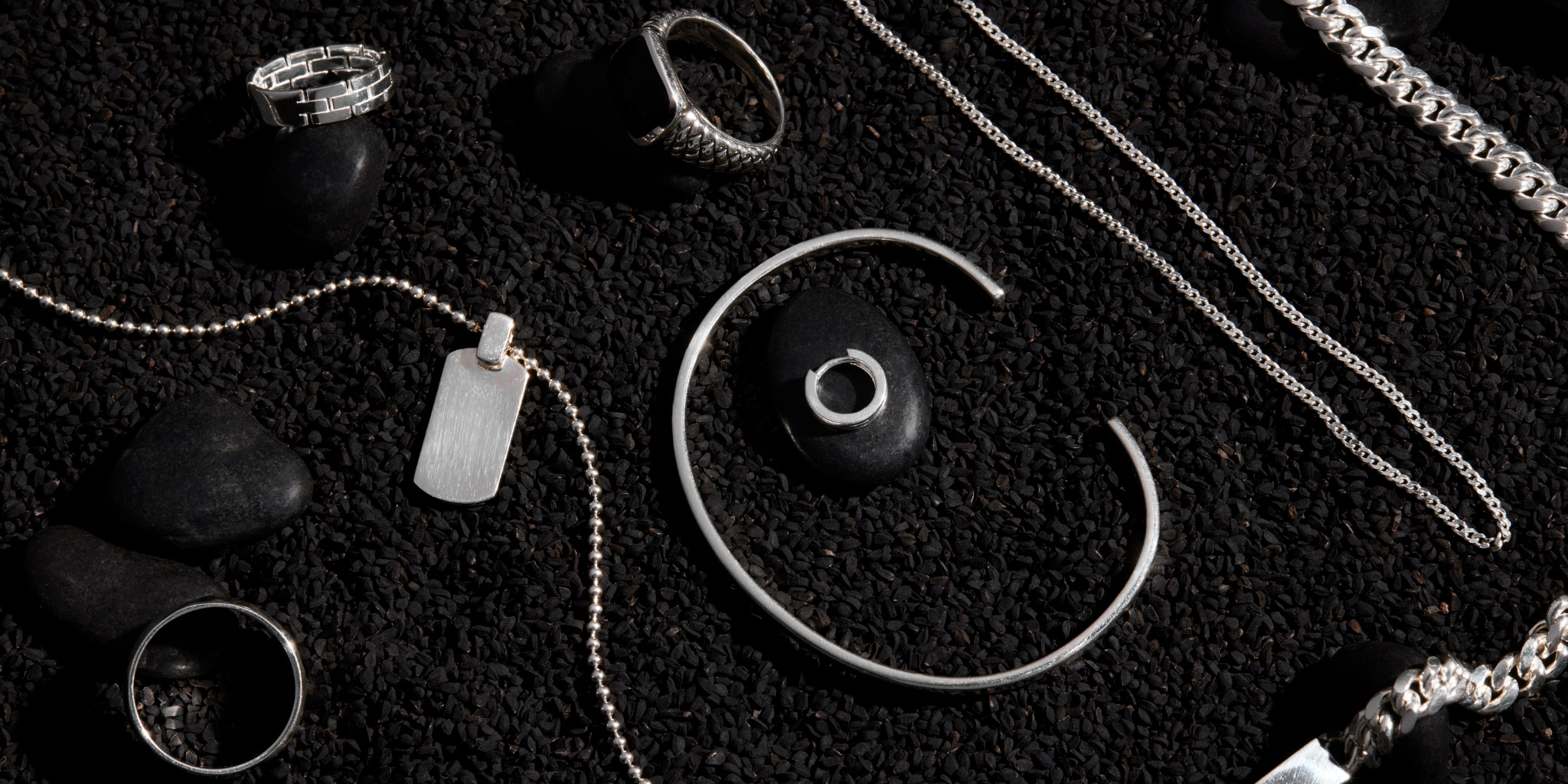 mens sterling silver jewellery collection on a black stone background